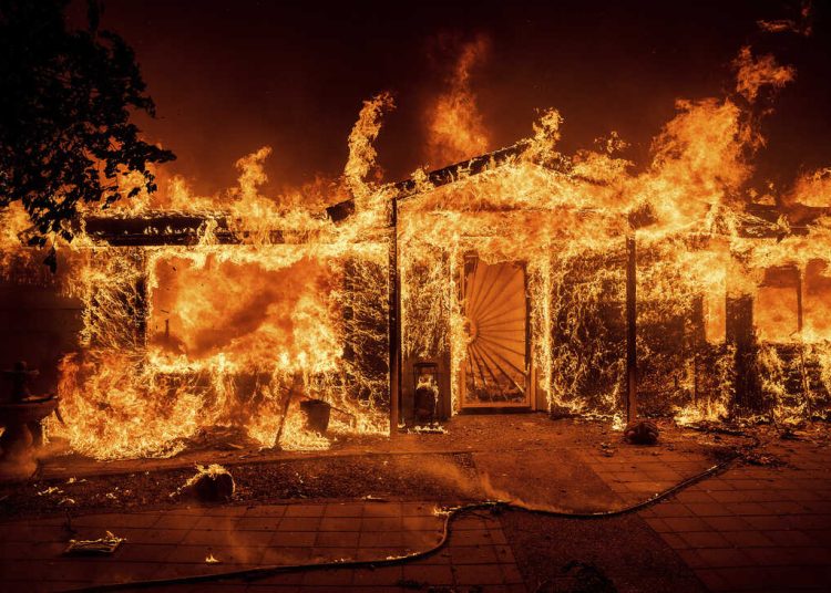Flames consume a home on Triangle Rd. as the Oak Fire burns in Mariposa County, Calif., on Saturday, July 23, 2022. (AP Photo/Noah Berger)